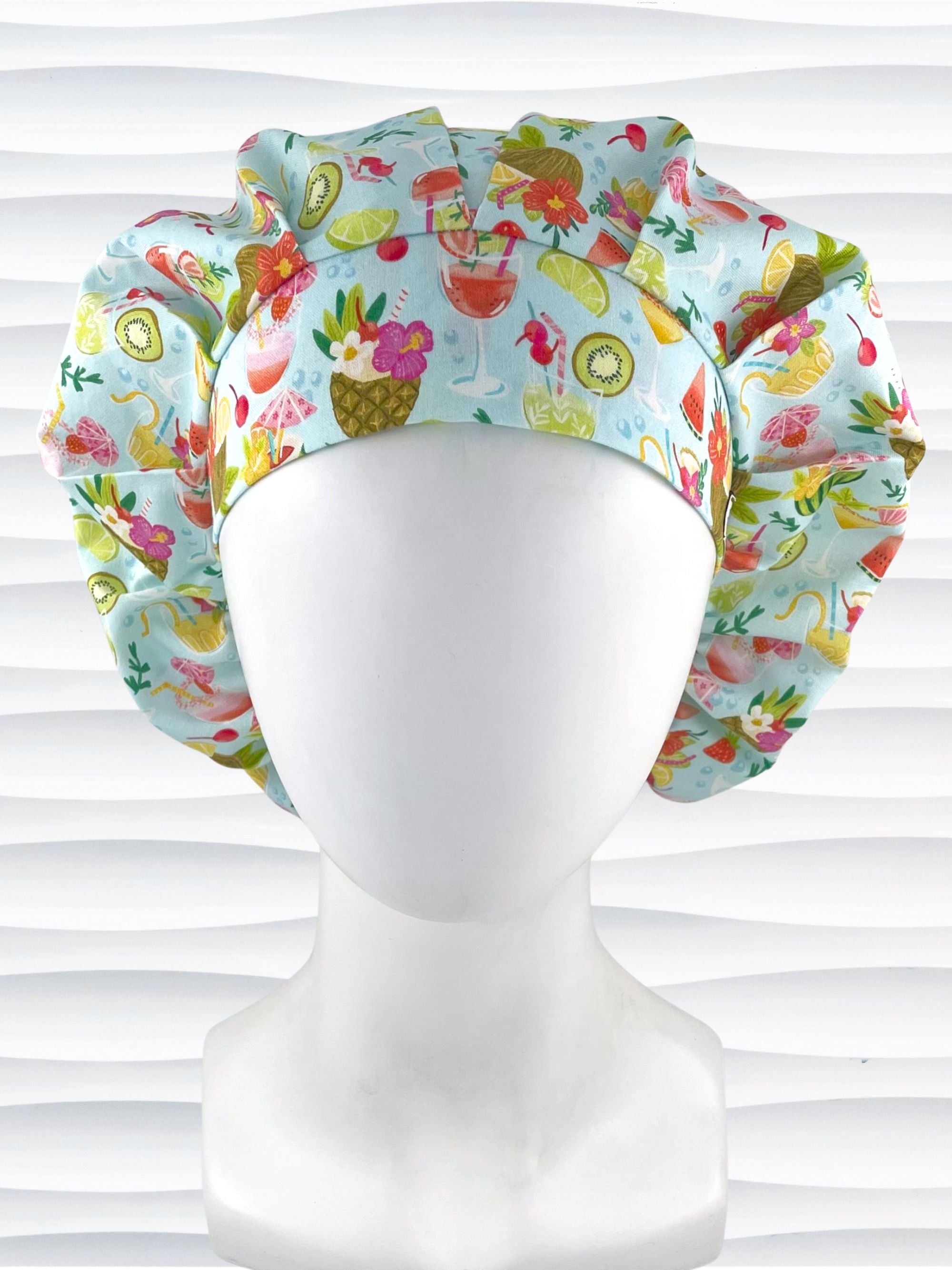 Bouffant surgical scrub cap by JensCaps with iconic tropical drinks with umbrellas and flowers in pinks and yellows and greens on light blue cotton fabric.