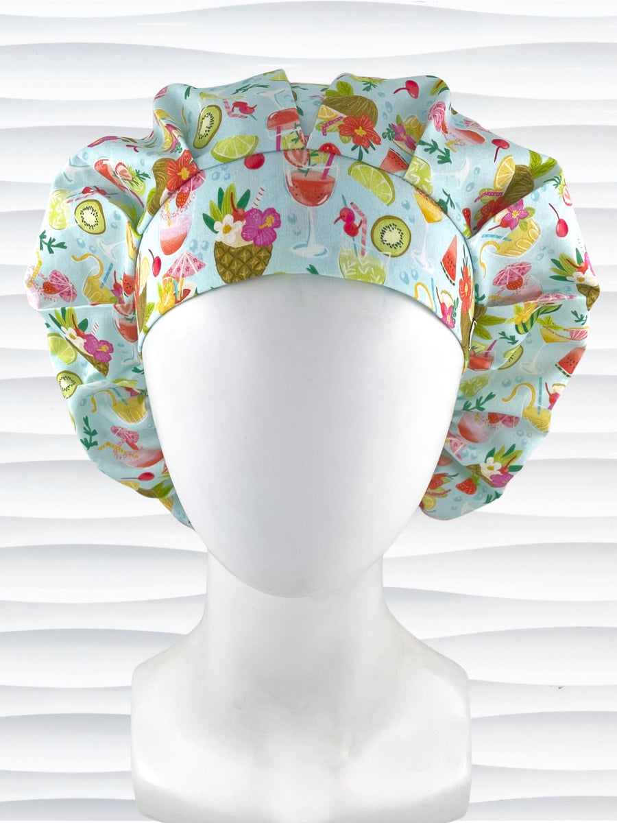 Bouffant surgical scrub cap by JensCaps with iconic tropical drinks with umbrellas and flowers in pinks and yellows and greens on light blue cotton fabric.