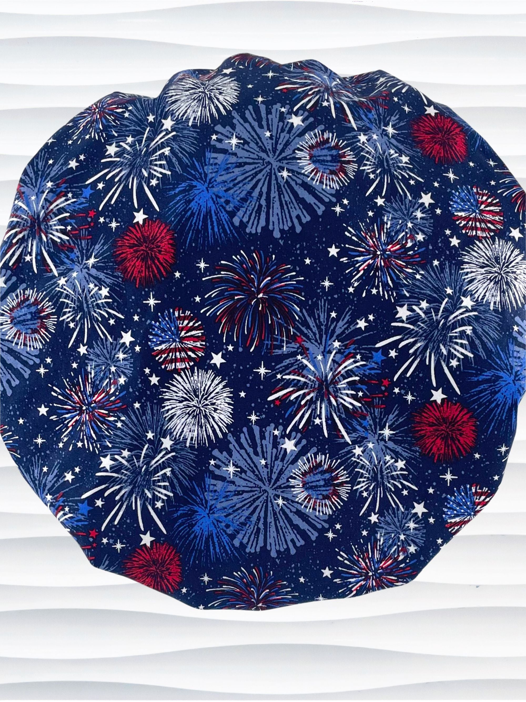 Bouffant style surgical scrub cap by JensCaps with fireworks and stars in red white and blue all over navy blue cotton fabric.