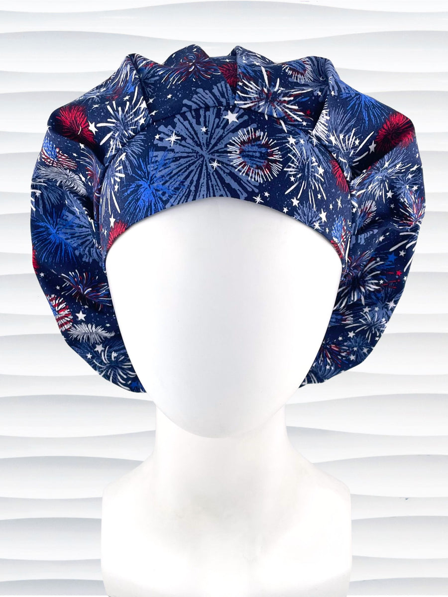 Bouffant style surgical scrub cap by JensCaps with fireworks and stars in red white and blue all over navy blue cotton fabric.