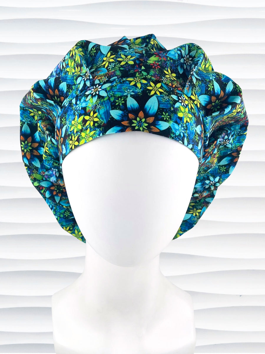 Bouffant style surgical scrub cap with electric bright flowers in green, yellow, white, orange, and blue all over a dark background cotton fabric.