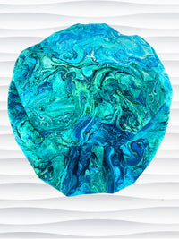 Euro Pixie style surgical scrub cap with a marbled pattern of blues and green that look like ocean tide pools or marbled turquoise on cotton fabric.