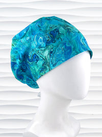 Euro Pixie style surgical scrub cap with a marbled pattern of blues and green that look like ocean tide pools or marbled turquoise on cotton fabric.