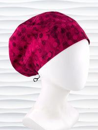 Euro Pixie style surgical scrub cap with a muted pattern of black circles and lines on deep red or magenta cotton fabric.