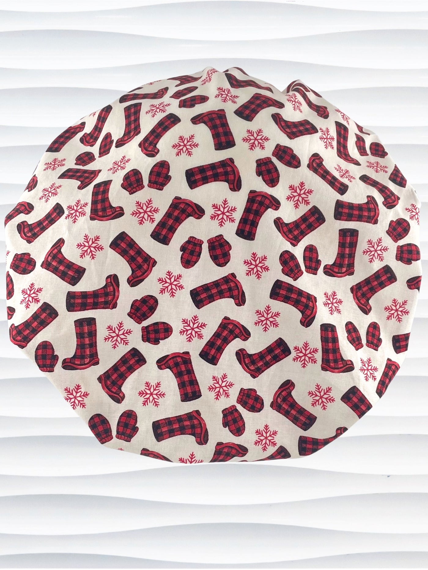 Bouffant style surgical scrub cap with snowflakes and red and black buffalo check winter boots and mittens on cotton fabric.