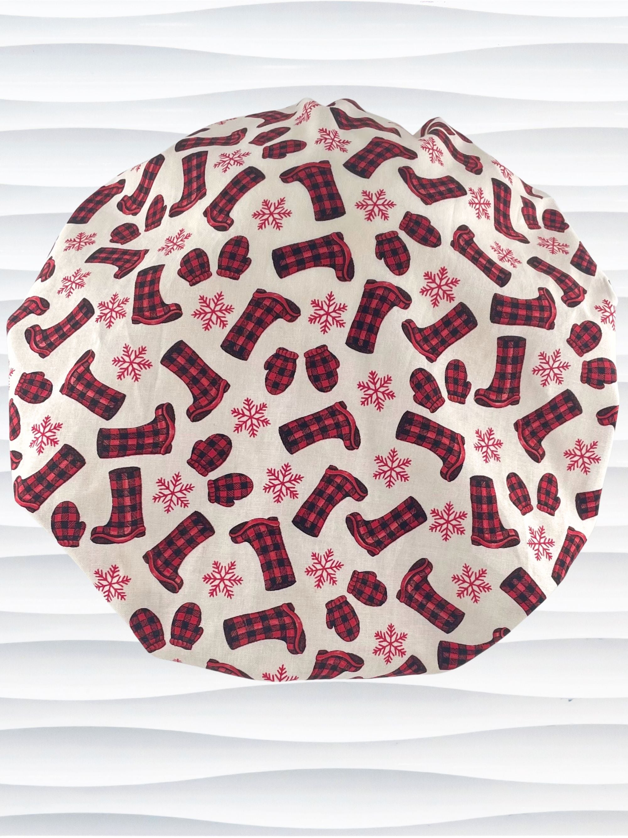 Bouffant style surgical scrub cap with snowflakes and red and black buffalo check winter boots and mittens on cotton fabric.