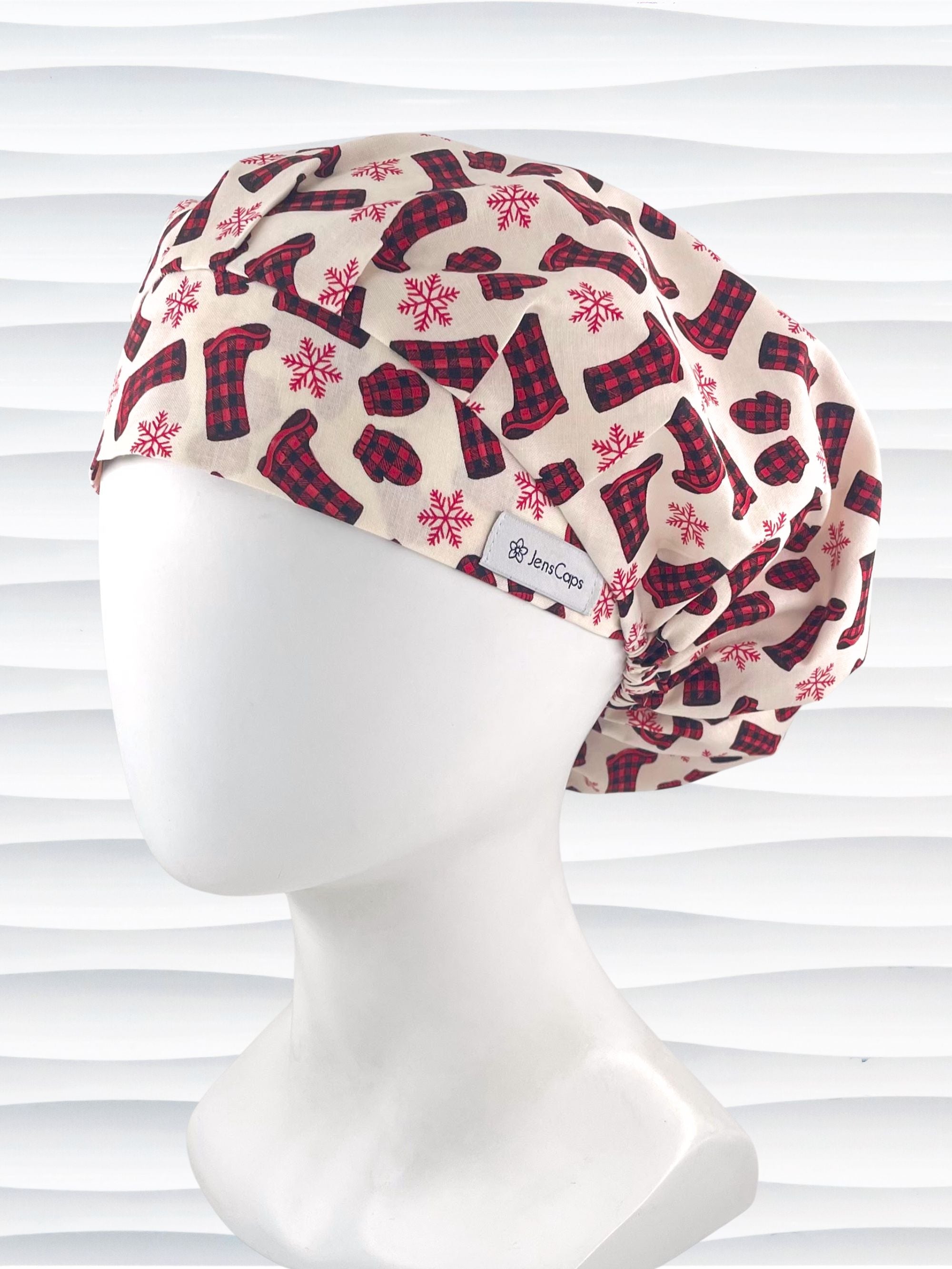 Bouffant style surgical scrub cap with snowflakes and red and black buffalo check winter boots and mittens on cotton fabric.