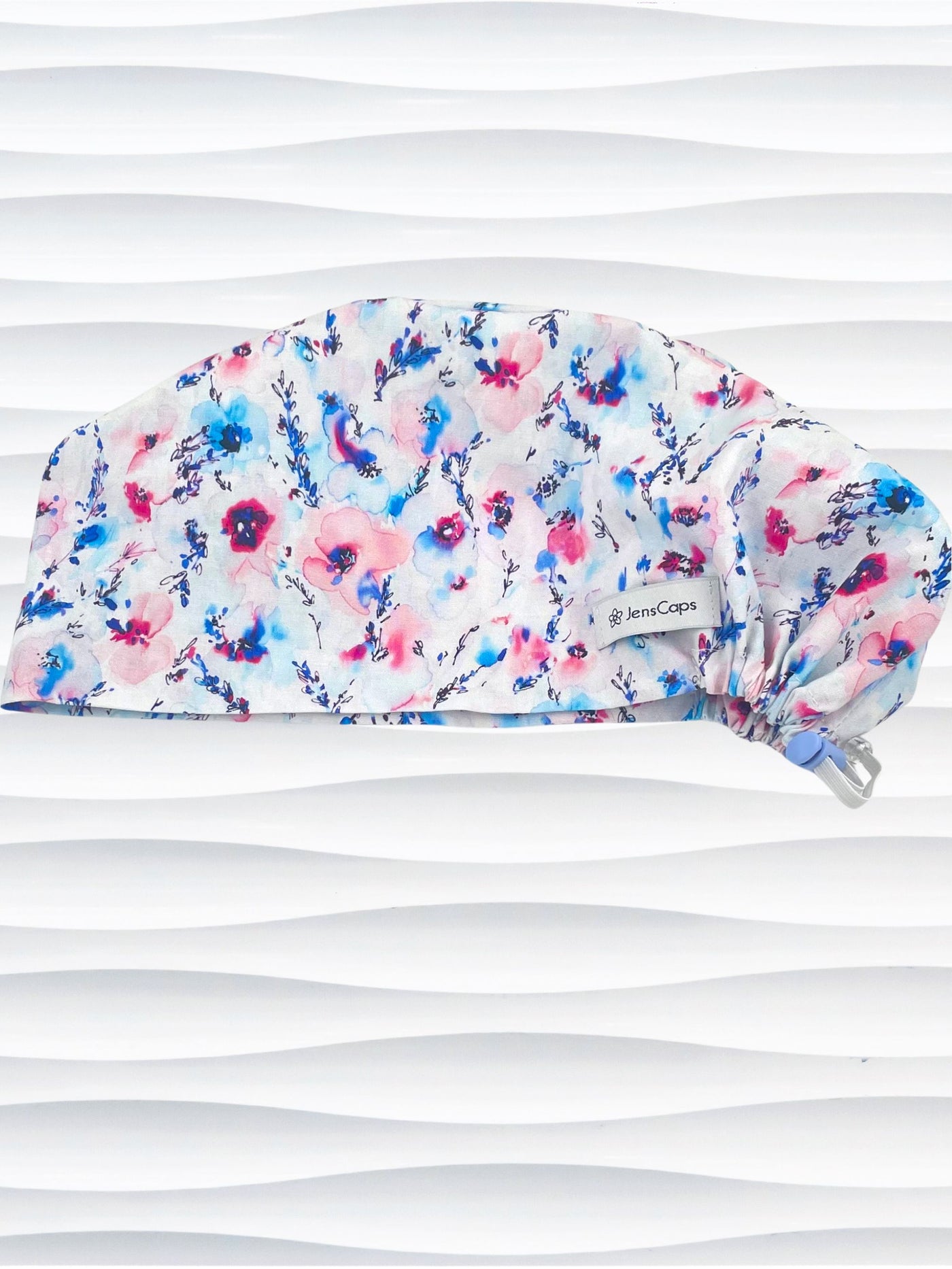 Women's euro pixie scrub cap with watercolor floral print in pink, blue, and purple on a white background, ideal for nurses, doctors, and medical professionals seeking stylish and comfortable headwear