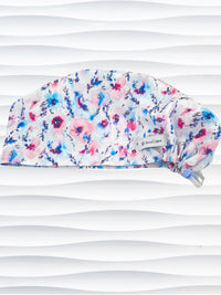 Women's euro pixie scrub cap with watercolor floral print in pink, blue, and purple on a white background, ideal for nurses, doctors, and medical professionals seeking stylish and comfortable headwear