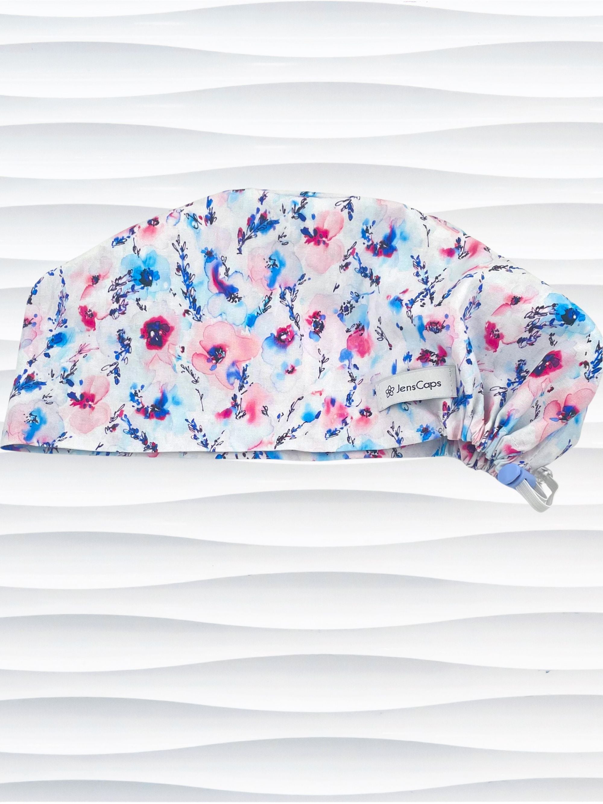 Women's euro pixie scrub cap with watercolor floral print in pink, blue, and purple on a white background, ideal for nurses, doctors, and medical professionals seeking stylish and comfortable headwear