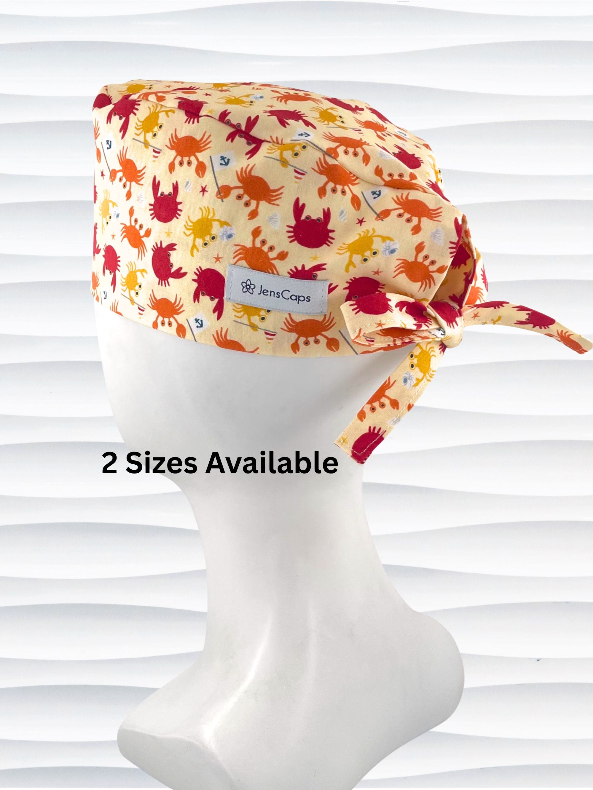 Colorful crab print surgical scrub cap featuring orange, red, and yellow cartoon crabs on cream fabric, displayed on mannequin head – handmade nurse and doctor scrub hat by JensCaps