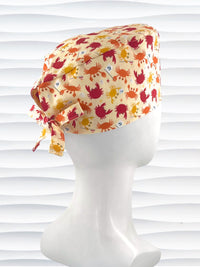 Colorful crab print surgical scrub cap featuring orange, red, and yellow cartoon crabs on cream fabric, displayed on mannequin head – handmade nurse and doctor scrub hat by JensCaps