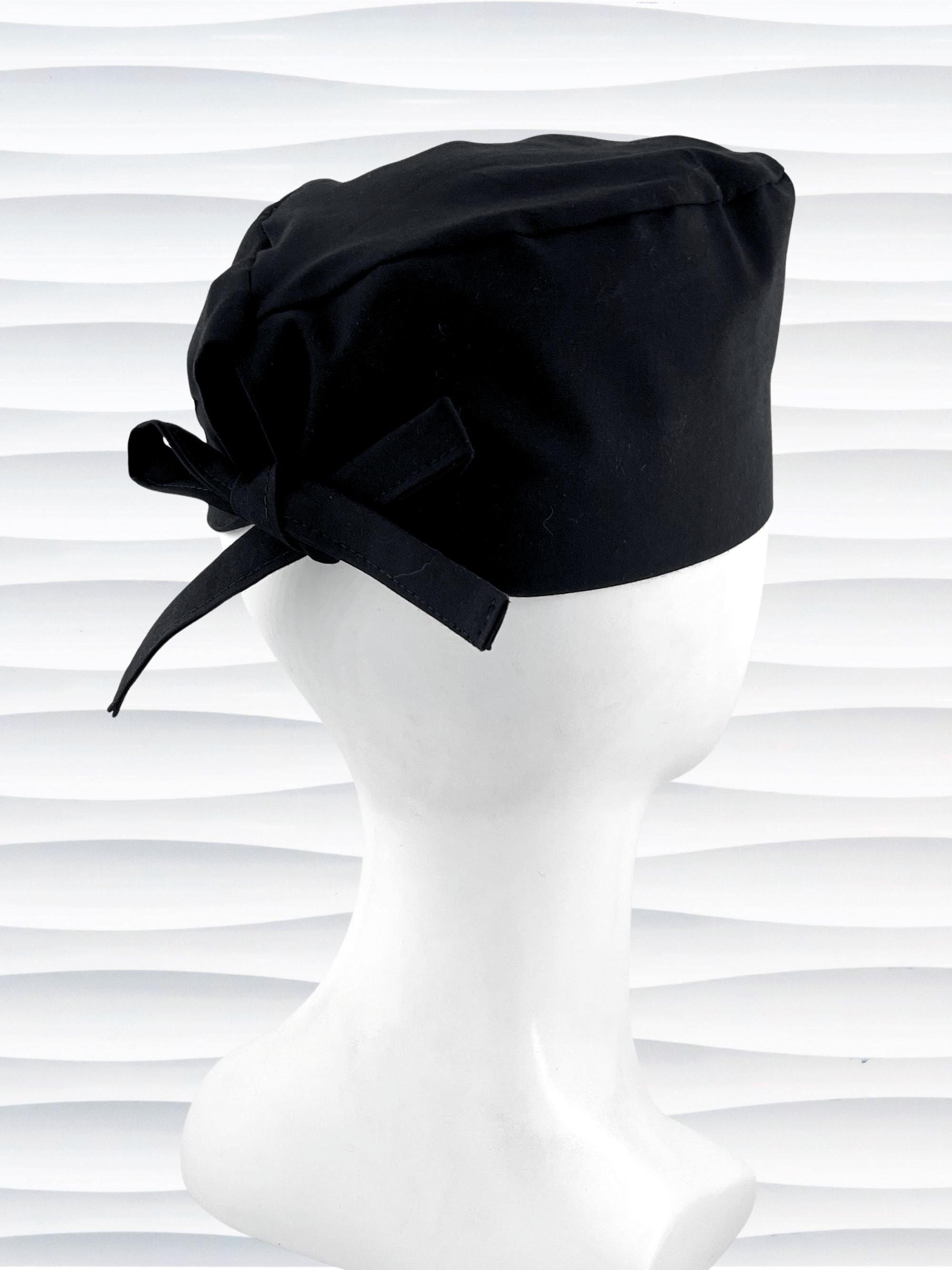 Surgeon style surgical scrub cap with solid black premium cotton and shown on white mannequin head