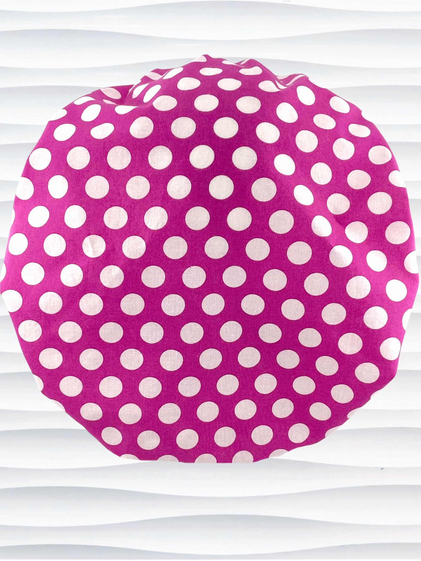 Bouffant style surgical scrub cap by JensCaps with large white dots on raspberry colored cotton fabric.