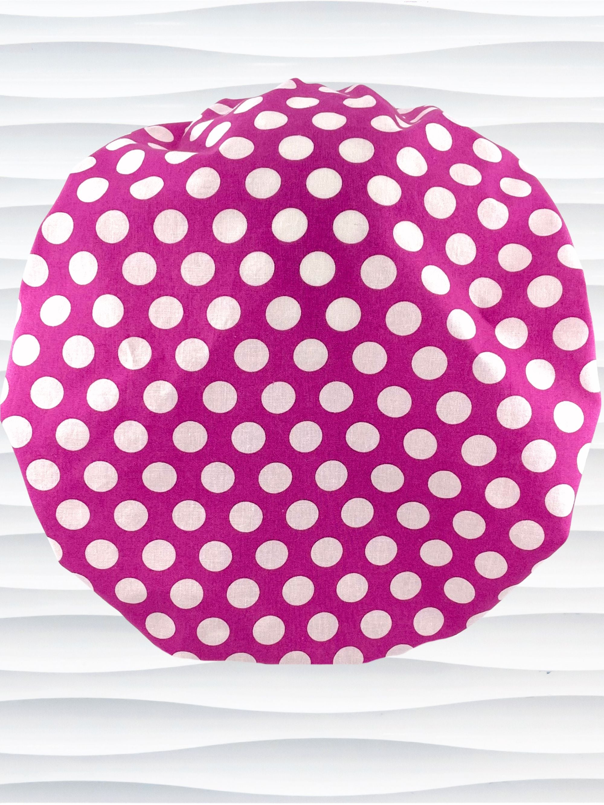 Bouffant style surgical scrub cap by JensCaps with large white dots on raspberry colored cotton fabric.