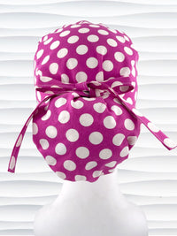 Euro Pony style ponytail surgical scrub cap by JensCaps with large white dots on raspberry colored cotton fabric.