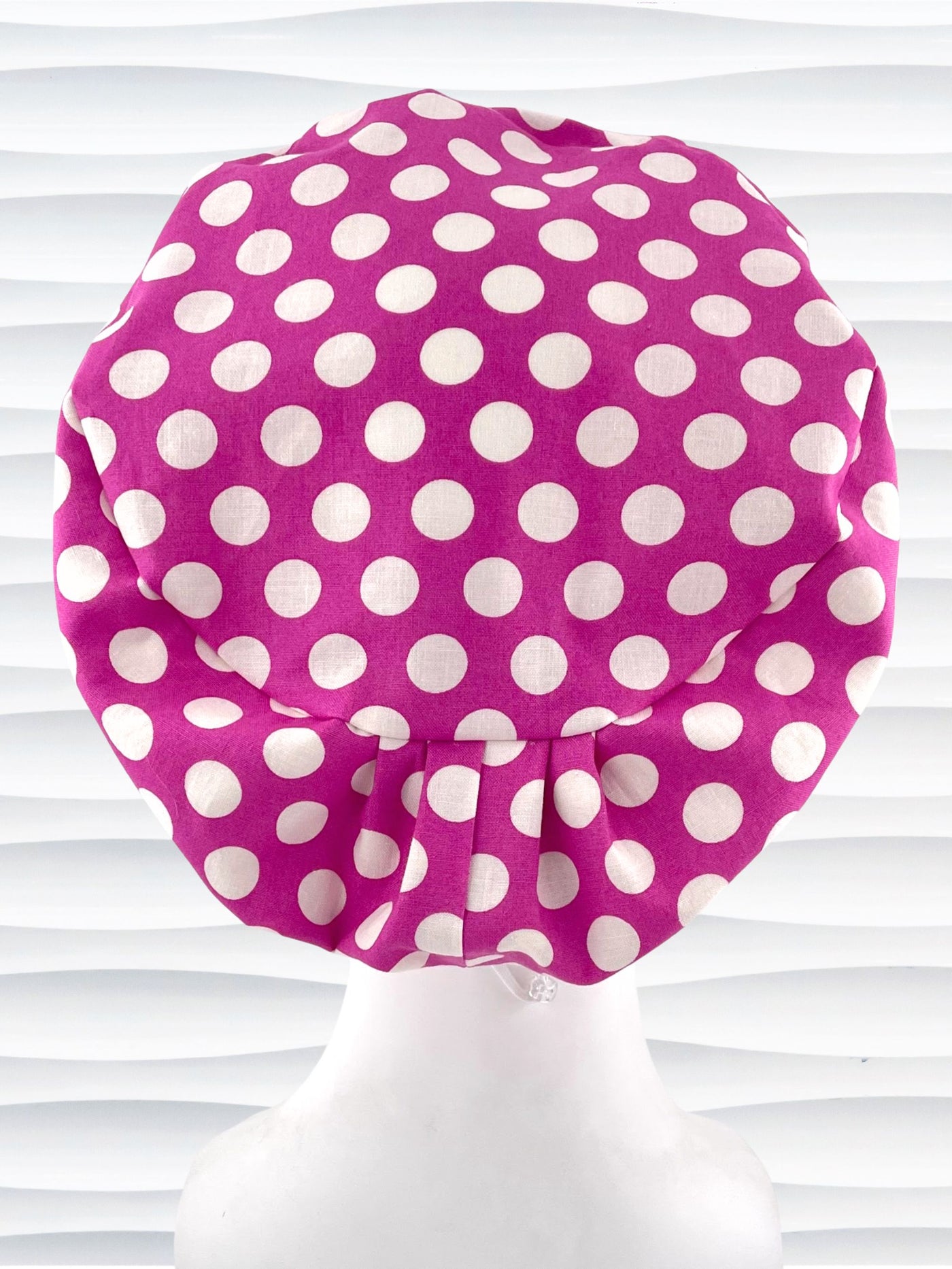 Euro Pixie style surgical scrub cap with large white dots on raspberry colored cotton fabric.