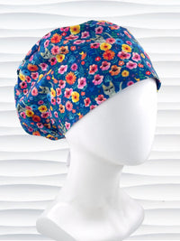 Euro Pixie style surgical scrub cap by JensCaps with gray cats hiding in a garden of yellow, pink, and red flowers on a dark blue cotton fabric
