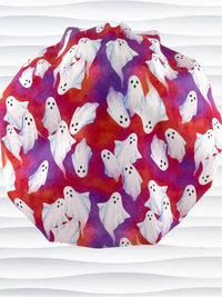 Bouffant style surgical scrub cap by JensCaps with white sheet ghosts tossed all aver an ombre red and purple cotton fabric.