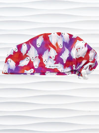 Euro Pixie style surgical scrub cap by JensCaps with white sheet ghosts tossed all aver an ombre red and purple cotton fabric.