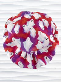 Euro Pixie style surgical scrub cap by JensCaps with white sheet ghosts tossed all aver an ombre red and purple cotton fabric.