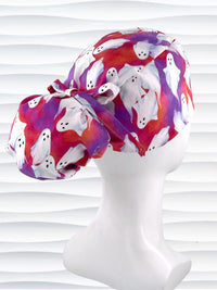 Ponytail style surgical scrub cap by JensCaps with white sheet ghosts tossed all aver an ombre red and purple cotton fabric.