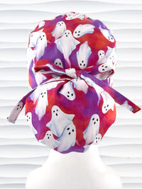 Euro Pony ponytail style surgical scrub cap by JensCaps with white sheet ghosts tossed all aver an ombre red and purple cotton fabric.