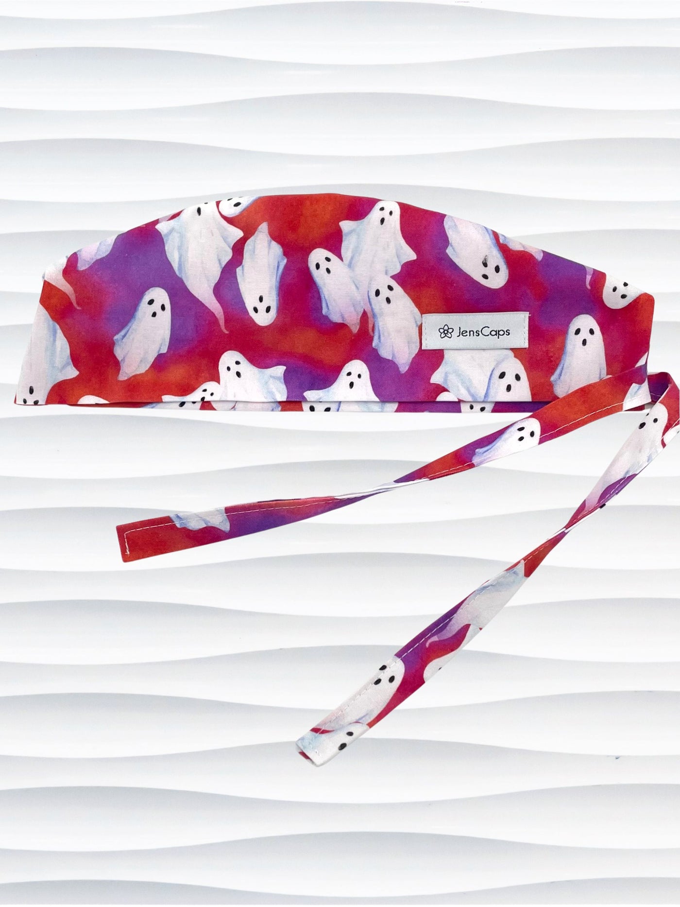 Surgeon style surgical scrub cap by JensCaps with white sheet ghosts tossed all aver an ombre red and purple cotton fabric.