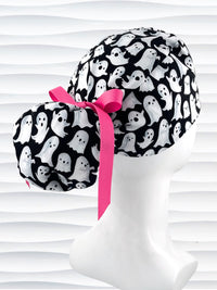 Ponytail style surgical scrub cap with animated white ghosts tossed all over black cotton fabric and finished with grosgrain ribbon ties.