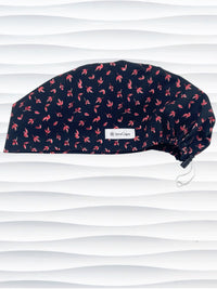 Black scrub cap with pink floral pattern on a mannequin head against a white background