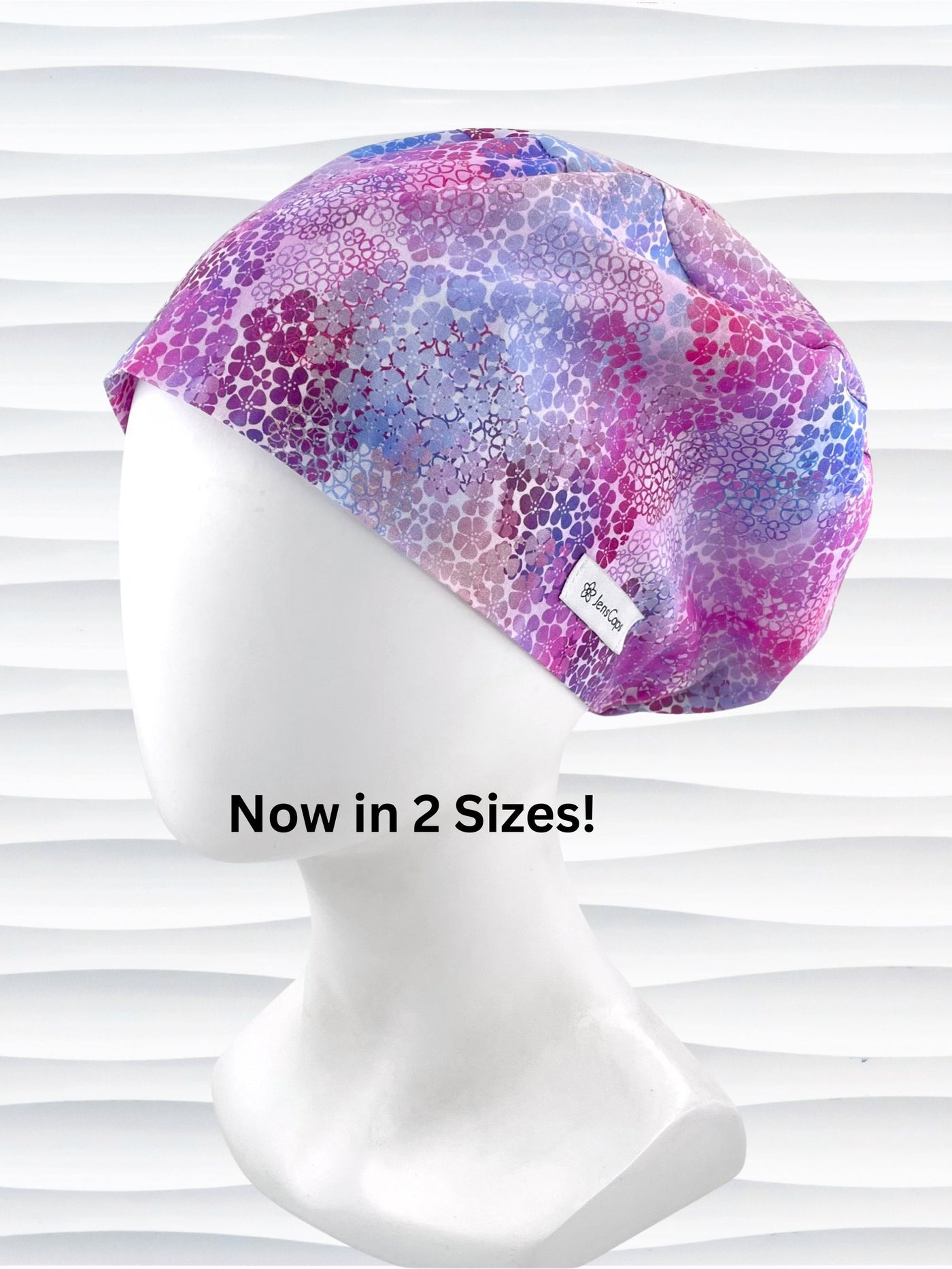 style surgical scrub cap by JensCaps with small daisies in pink, blue, and purple all over cotton fabric and displayed on a mannequin head