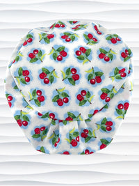 Euro Pixie style surgical scrub cap by JensCaps with red cherries blue polka dots on white cotton fabric and diplayed on a mannequin head.