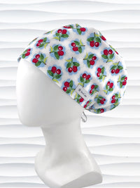Euro Pixie style surgical scrub cap by JensCaps with red cherries blue polka dots on white cotton fabric and diplayed on a mannequin head.