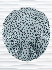 Euro Pixie style surgical scrub cap by JensCaps with a leopard print on light teal cotton fabric and displayed on a mannequin head.