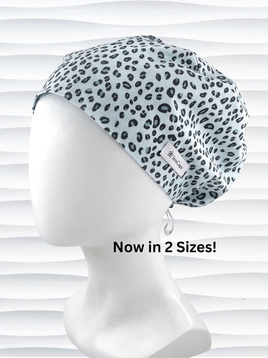 Euro Pixie style surgical scrub cap by JensCaps with a leopard print on light teal cotton fabric and displayed on a mannequin head.