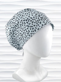 Euro Pixie style surgical scrub cap by JensCaps with a leopard print on light teal cotton fabric and displayed on a mannequin head.