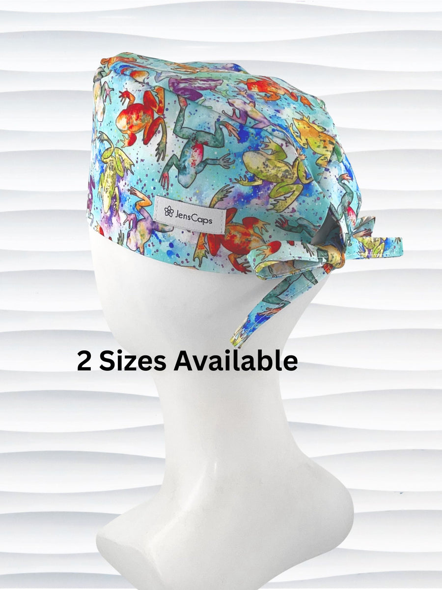 Surgical scrub cap by JensCaps in an adjustable tie-back style with a colorful watercolor frog print in orange, purple, green, and blue on an aqua background and displayed on a mannequin head 