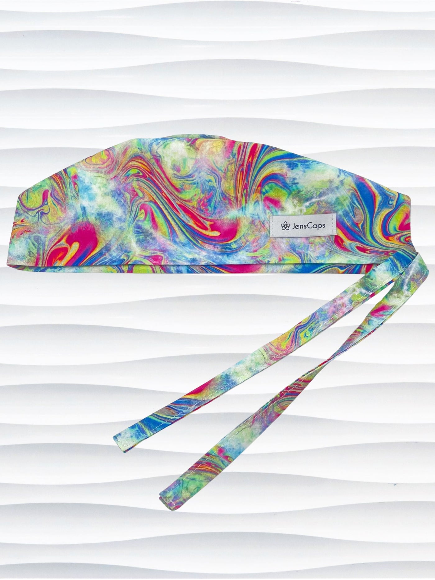 Tie-back surgical scrub cap by JensCaps with an abstract marbled swirl print in blue, magenta, yellow, and green and displayed on a white mannequin head.