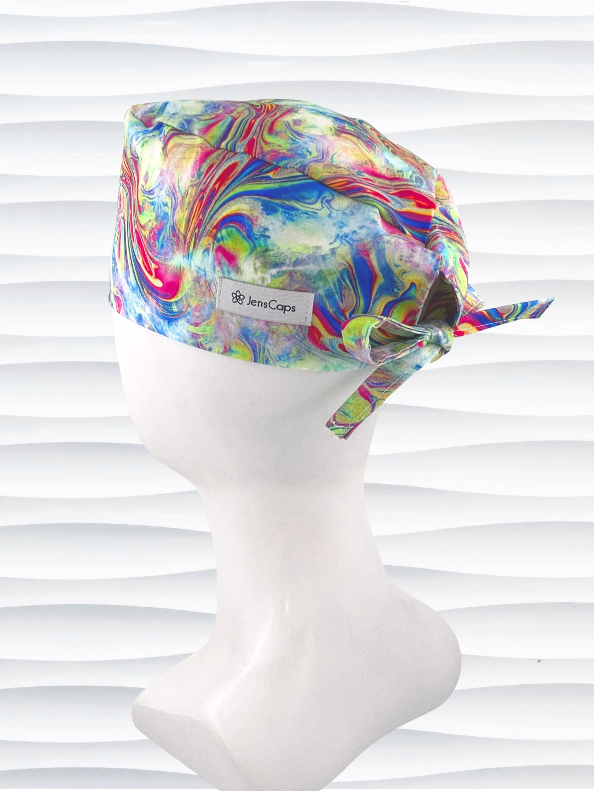 Tie-back surgical scrub cap by JensCaps with an abstract marbled swirl print in blue, magenta, yellow, and green and displayed on a white mannequin head.