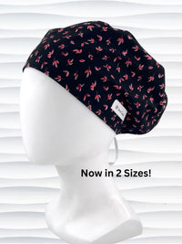 Black scrub cap with pink floral pattern on a mannequin head against a white background.