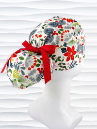 Ponytail style surgical scrub cap by jenscaps with holly berries, mistletoe, and poinsettias all over this white cotton fabric and tied with a ribbon