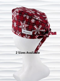 Red and white plaid scrub cap with snowflakes on a mannequin head against a white background.