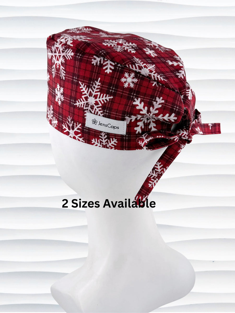 Red and white plaid scrub cap with snowflakes on a mannequin head against a white background.