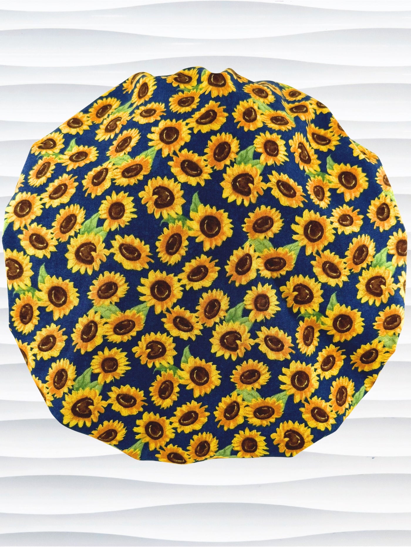 Bouffant style surgical scrub cap by jenscaps with sunflowers tossed all over a dark blue background cotton fabric