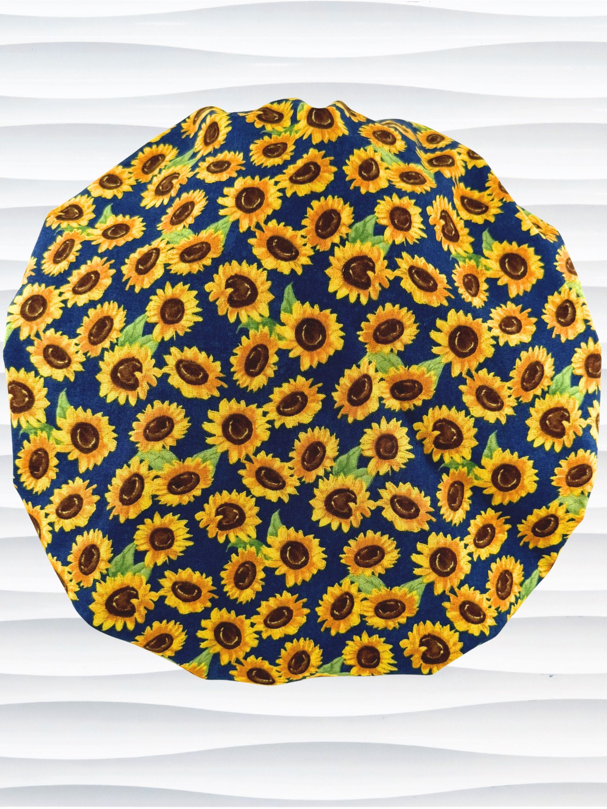 Bouffant style surgical scrub cap by jenscaps with sunflowers tossed all over a dark blue background cotton fabric