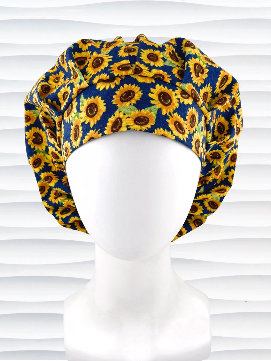 Bouffant style surgical scrub cap by jenscaps with sunflowers tossed all over a dark blue background cotton fabric