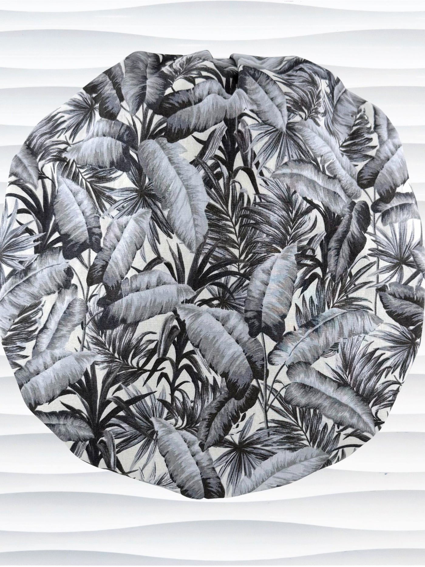 Bouffant style surgical scrub cap by JensCaps with black and white palm trees and displayed on a white mannequin head.