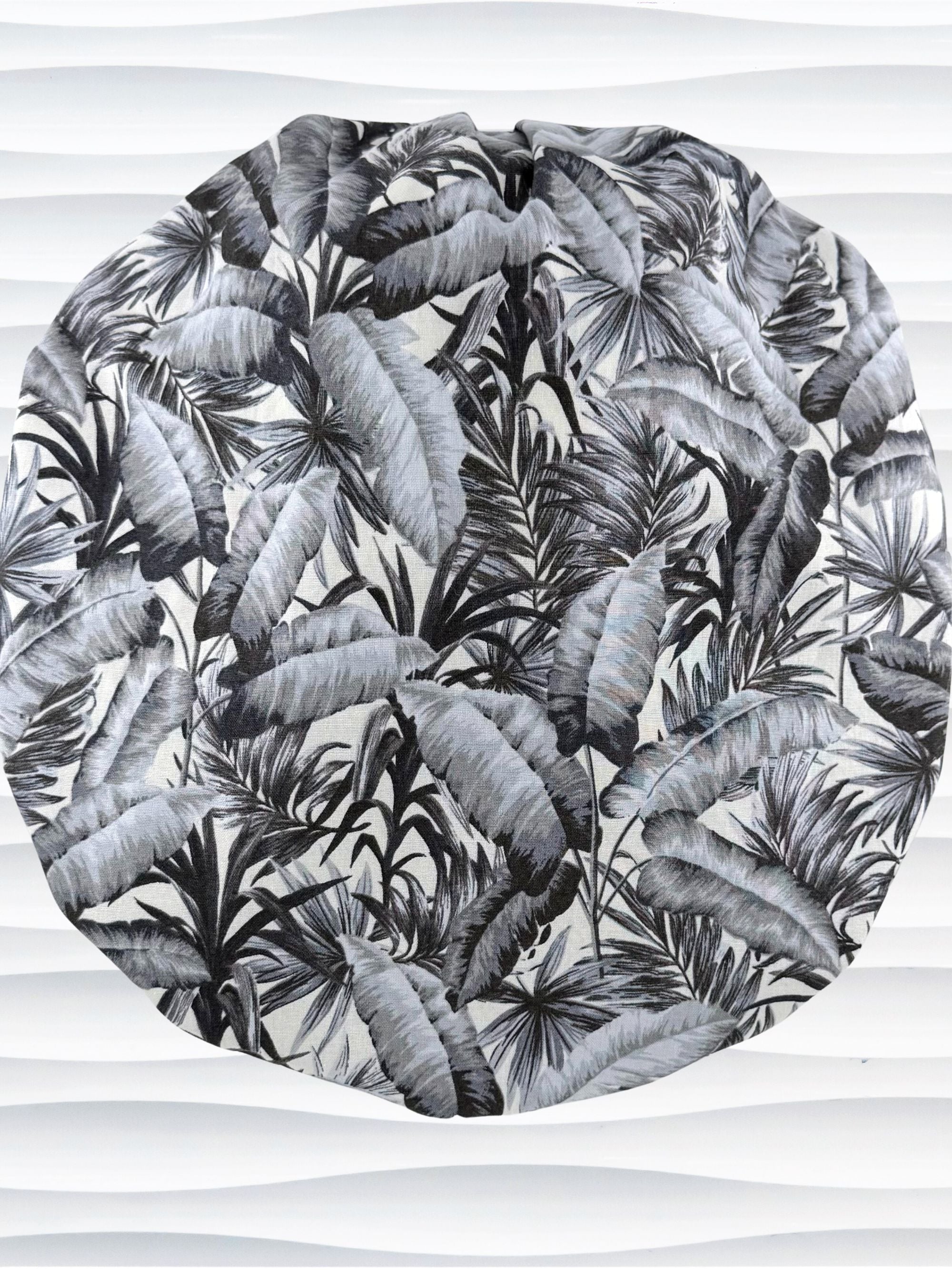 Bouffant style surgical scrub cap by JensCaps with black and white palm trees and displayed on a white mannequin head.