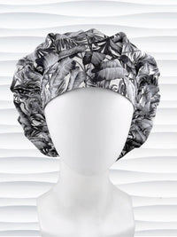 Bouffant style surgical scrub cap by JensCaps with black and white palm trees and displayed on a white mannequin head.