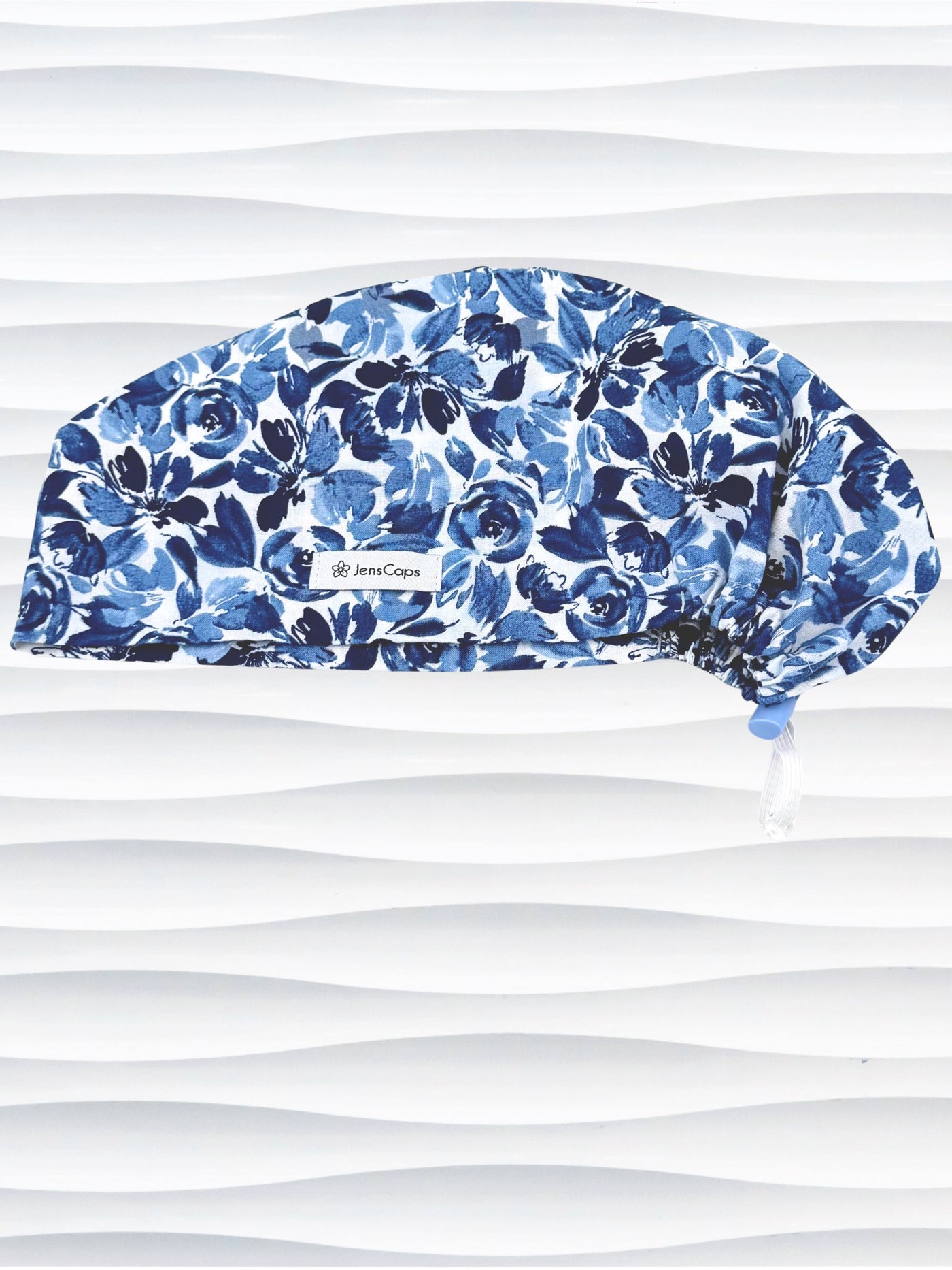 Euro Pixie style surgical scrub cap by JensCaps with flowers in varying shades of blue with a white background displayed on a white mannequin head.